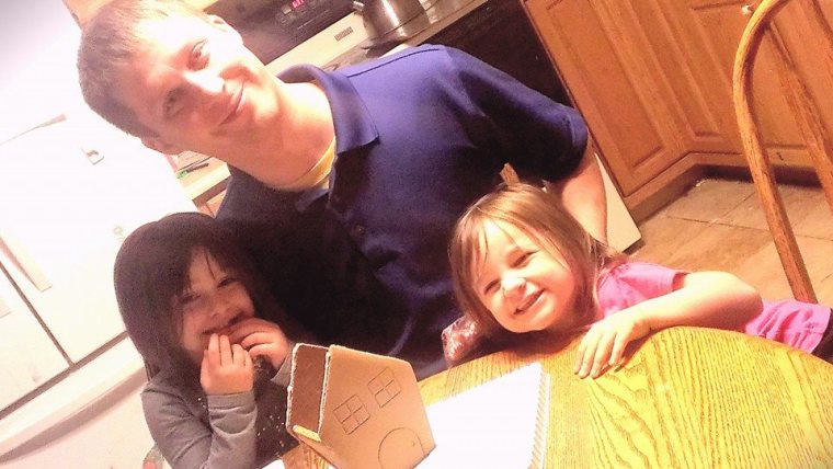 Ben doin work on the ginger bread house with the girls 